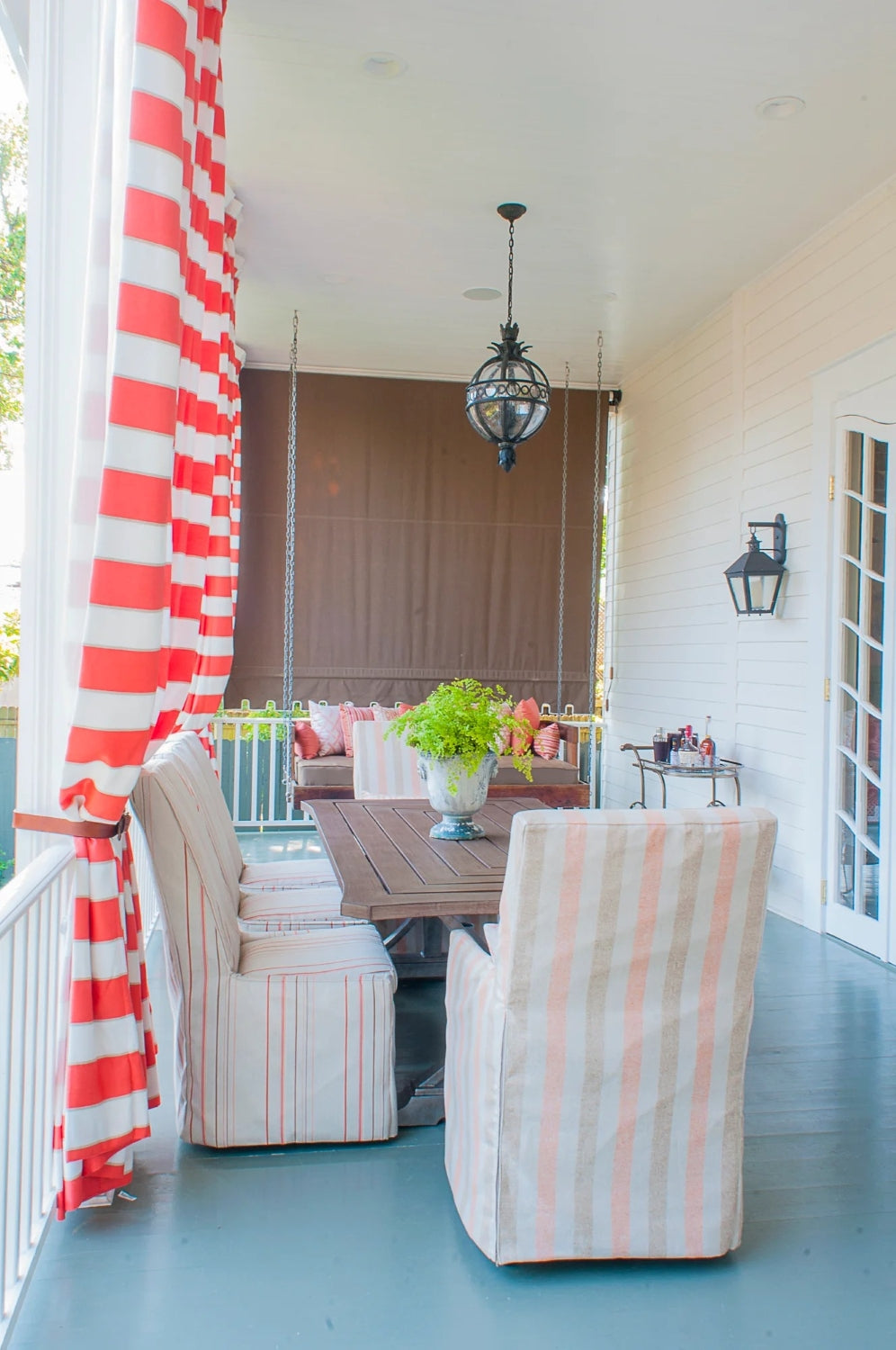 Campanile Outdoor Pendant by Troy Lighting hanging over a decorative backyard patio dining area